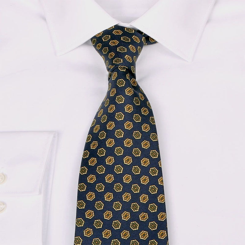 Dunkelblaue Saglia-Krawatte aus reiner Seide mit kleinen Blüten von BGENTS am Hemd gebunden