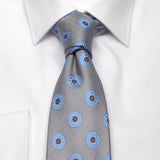 Graue Seiden-Jacquard Krawatte mit blauem Blüten-Muster von BGENTS am Hemd gebunden