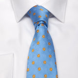 Hellblaue Seiden-Jacquard Krawatte mit gelben Blüten-Muster von BGENTS am Hemd gebunden